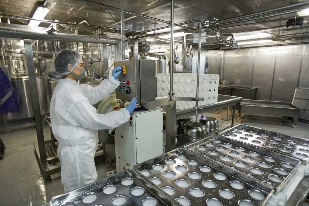 Female Worker Operating Conveyor at Food Factory